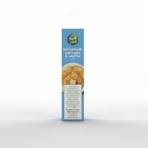 A Food Club Buttermilk Pancake & Waffle Mix box stands upright on a clean white background with soft studio lighting and a subtle shadow beneath it.